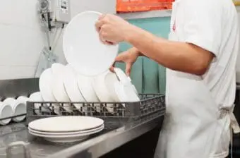 Restaurant worker washes dishes