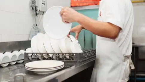 Restaurant worker washes dishes