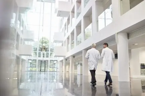 Two doctors talk as they walk through a hospital