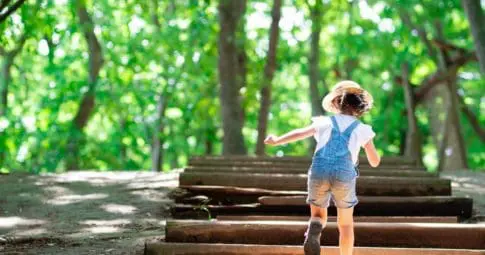 Little girl walking up sunny steps