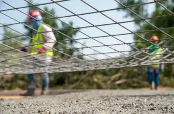 A steel wire net with construction workers in the background