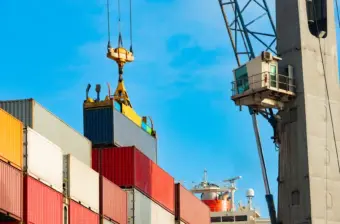 Cargo ship being loaded with containers at trade port