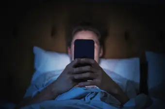 Person uses cellphone in bed
