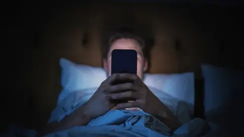 Person uses cellphone in bed