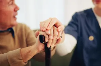 Older man with cane, with long-term care worker