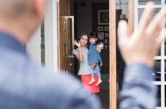 A dad waves goodbye to a mother and daughter