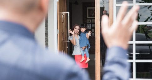 A dad waves goodbye to a mother and daughter