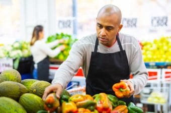 A worker at a grocery store arranges food