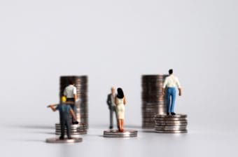 Workers look at stacks of coins representing wages