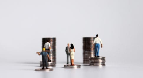 Workers look at stacks of coins representing wages