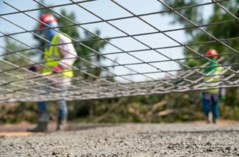 A steel wire net with construction workers in the background