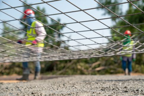 A steel wire net with construction workers in the background