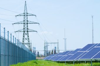Solar panels against high-voltage tower