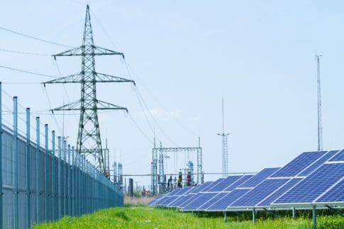 Solar panels against high-voltage tower