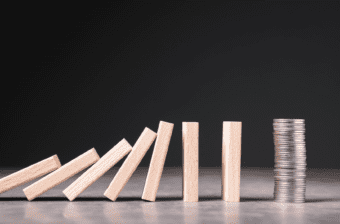 Blocks fall toward a stack of coins, representing unexpected events that could cause financial hardship for SNAP recipients