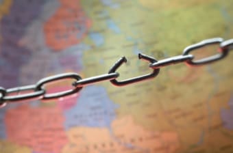 A broken chain over a map represents supply chain chaos