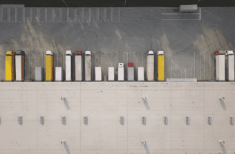 Trucks with shipping containers representing trade and tariffs